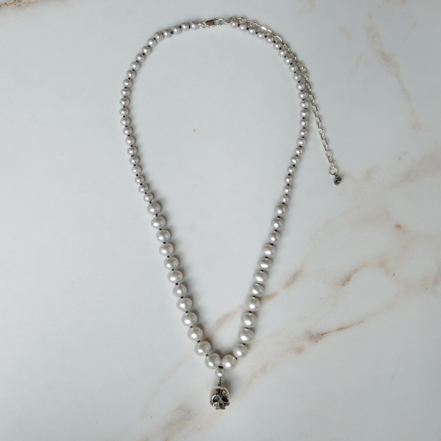 Hand strung grey freshwater pearls with a large sterling silver skull, made by hand in London by Charlie Shires