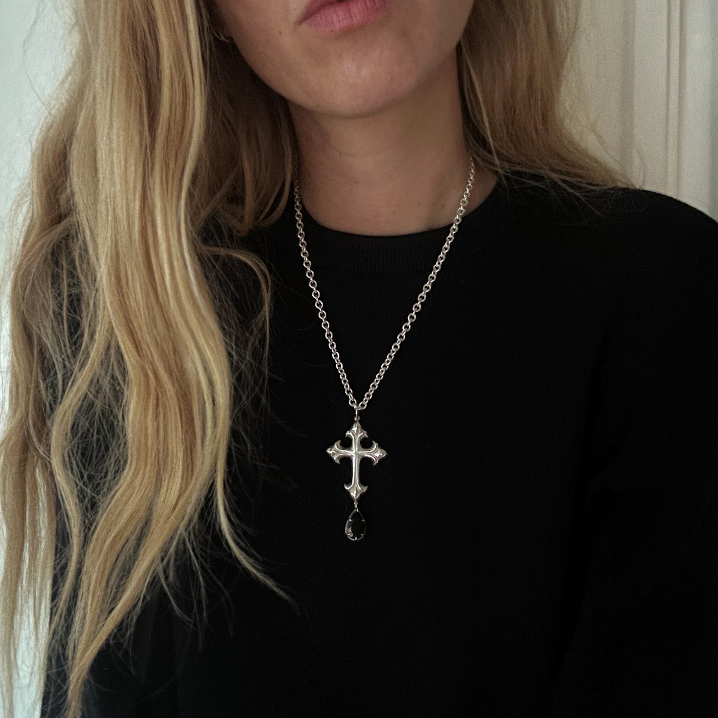 Hand carved crucifix necklace with pear shaped claw set drop black spinel. Made in sterling silver by Charlie Shires in London