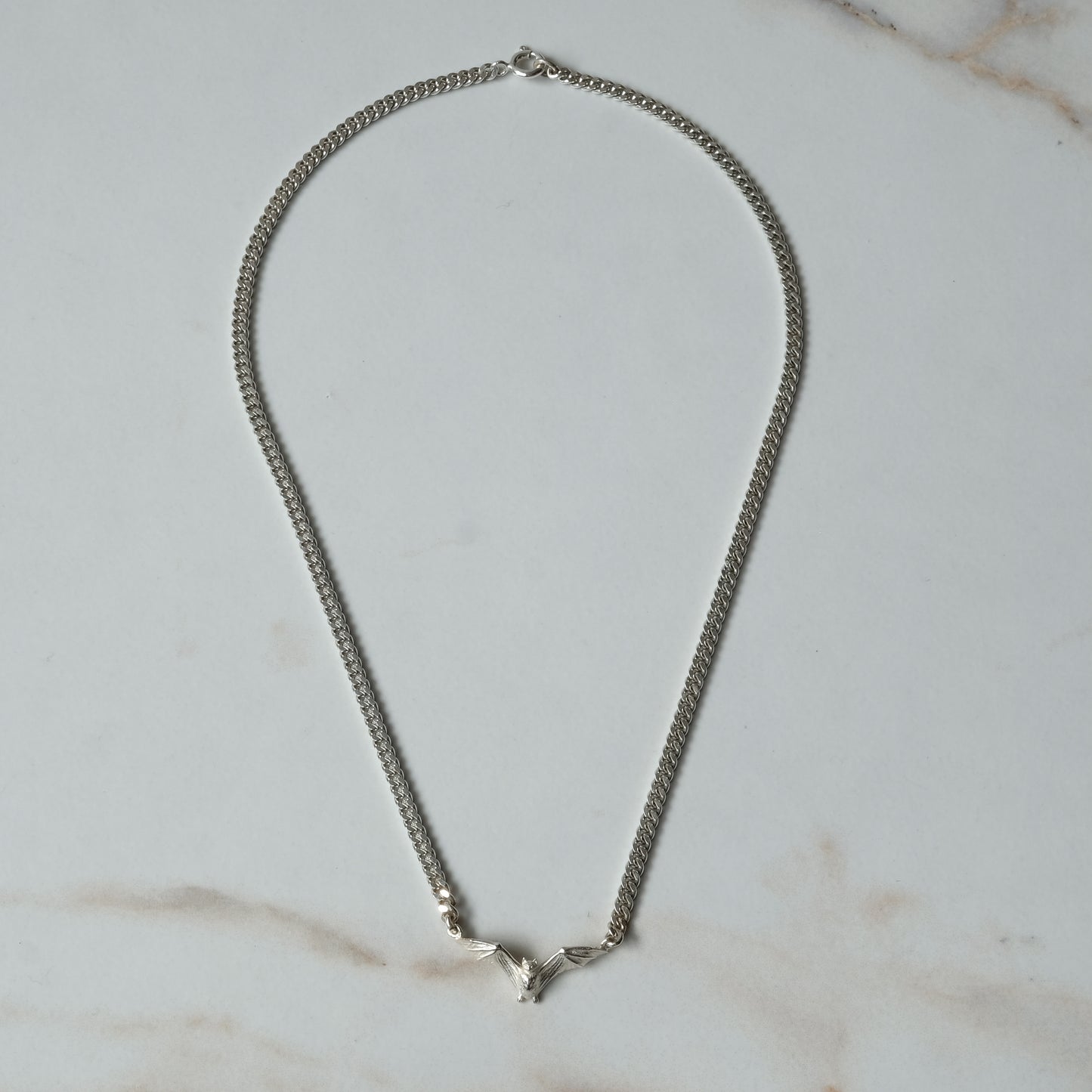 Bat necklace on curb link chain, made in sterling silver by Charlie Shires in London