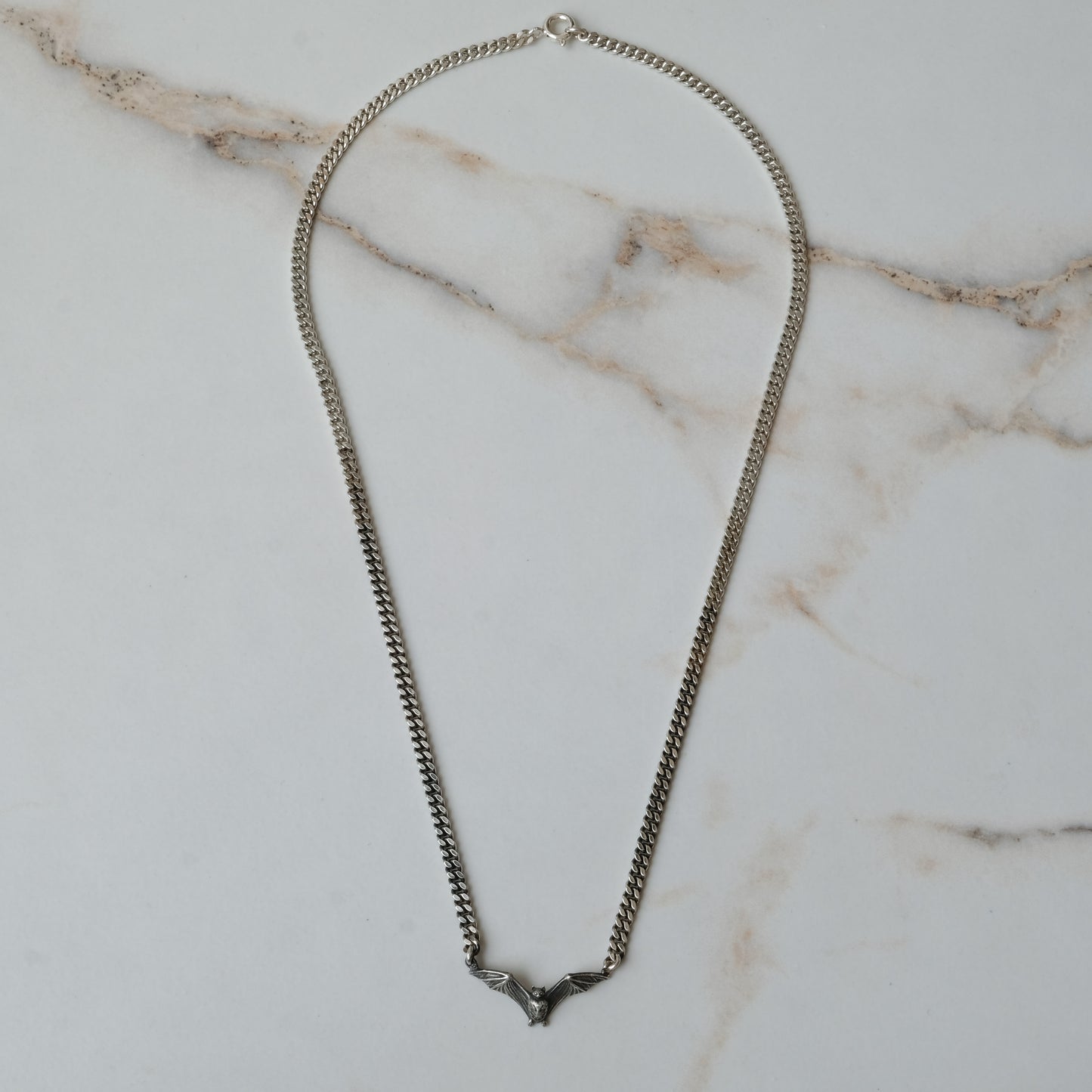 Bat necklace on curb link chain, made in sterling silver by Charlie Shires in London