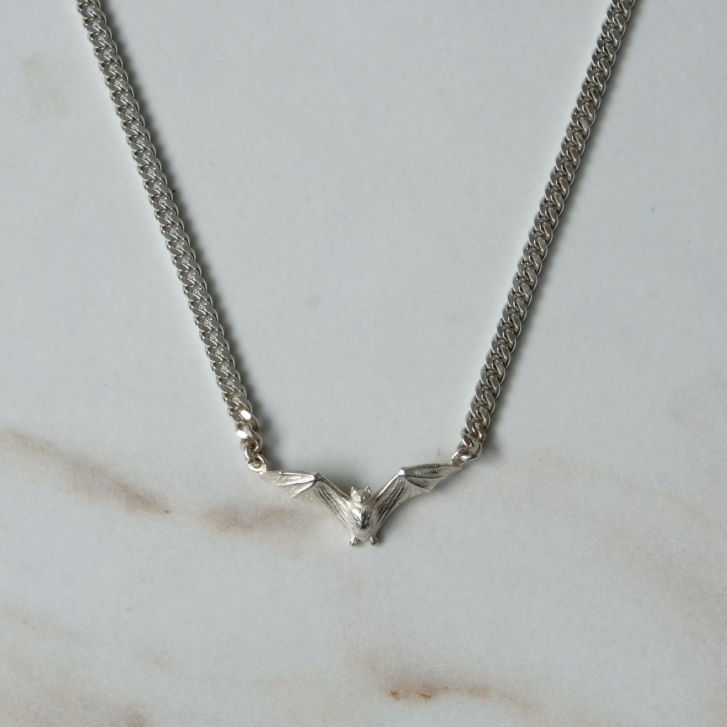 Bat necklace on curb link chain, made in sterling silver by Charlie Shires in London