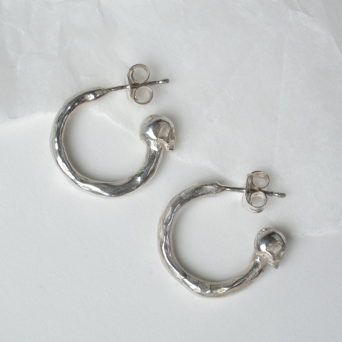 Small hoop earrings with molten detail and skulls at back