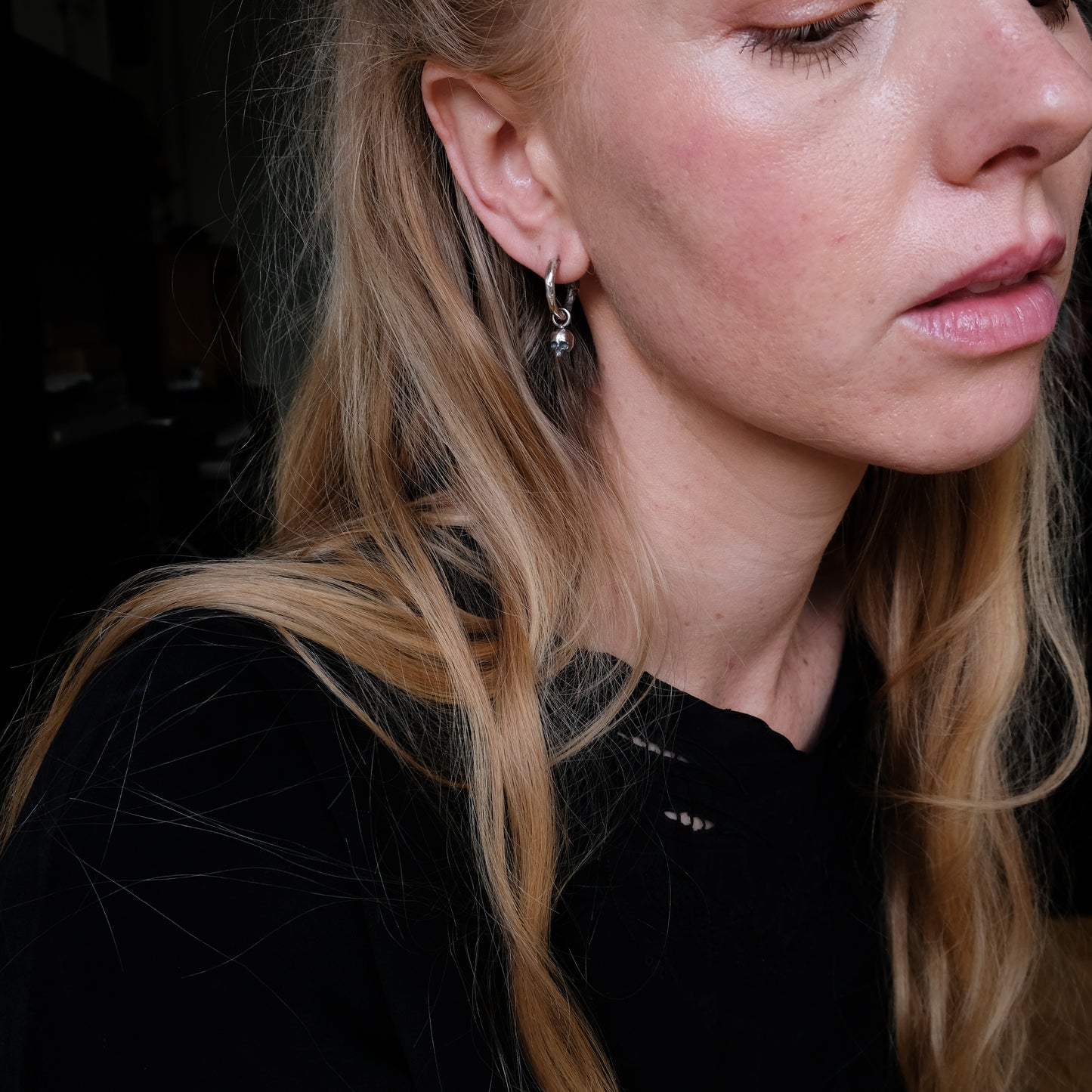 Molten style sterling silver earrings with hidden skull stoppers and skulls hanging. Made in London by Charlie Shires