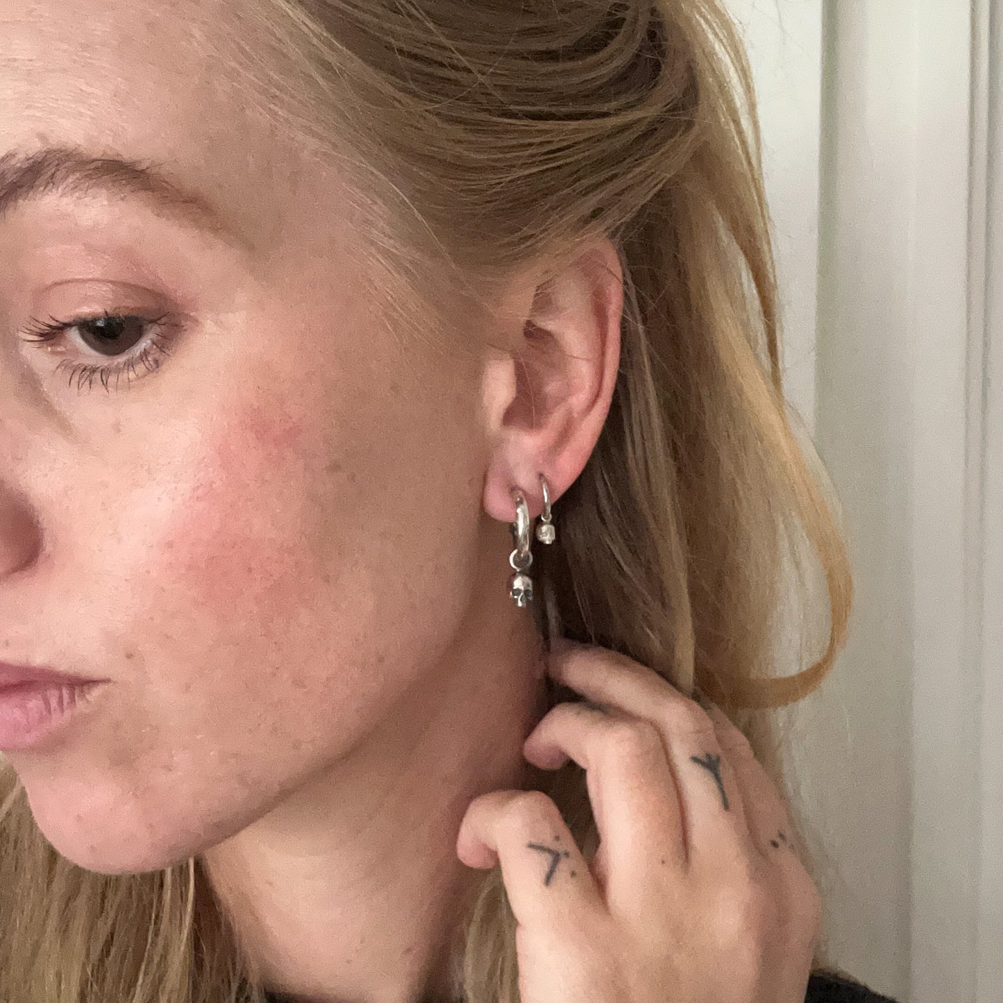 Sterling silver skull huggie hoop earrings made in London by Charlie Shires