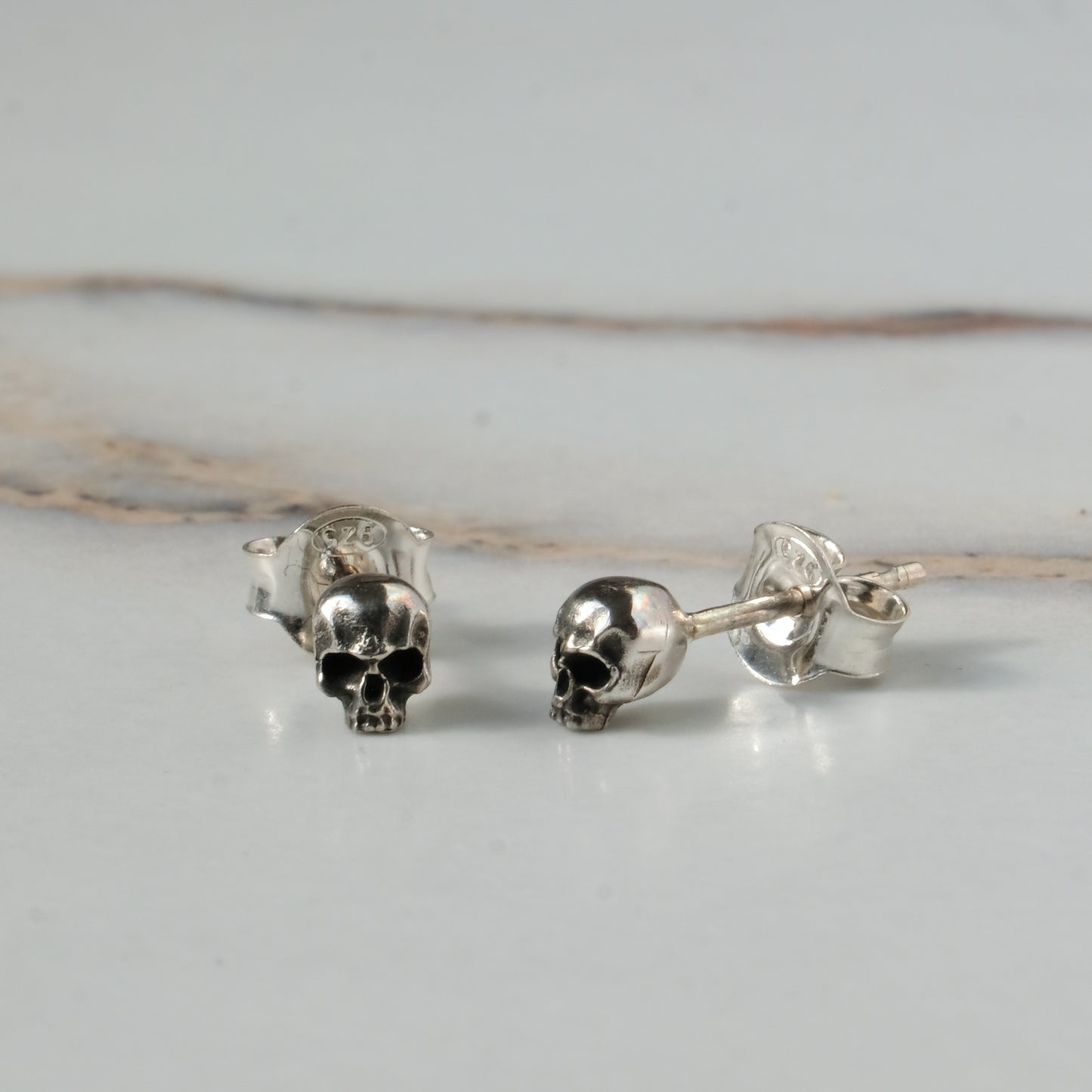Small skull studs made in sterling silver in London by Charlie Shires