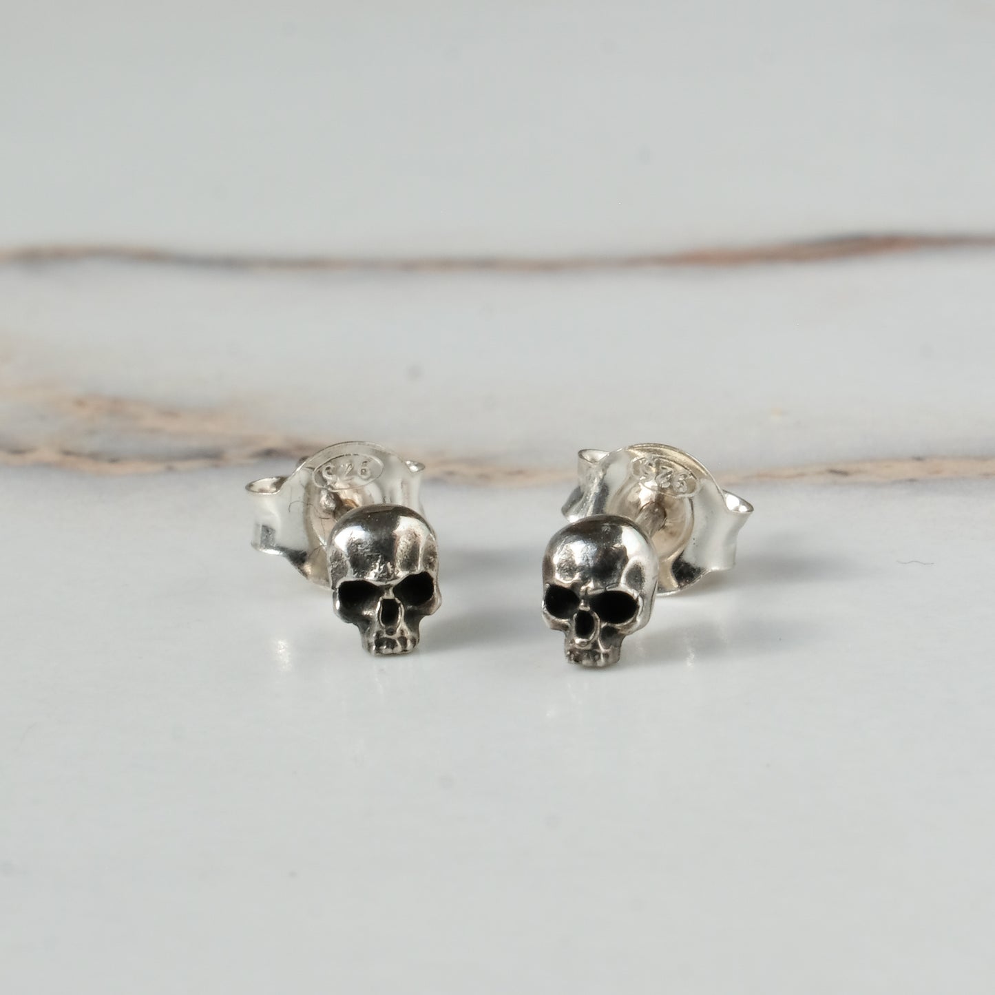 Small skull studs made in sterling silver in London by Charlie Shires