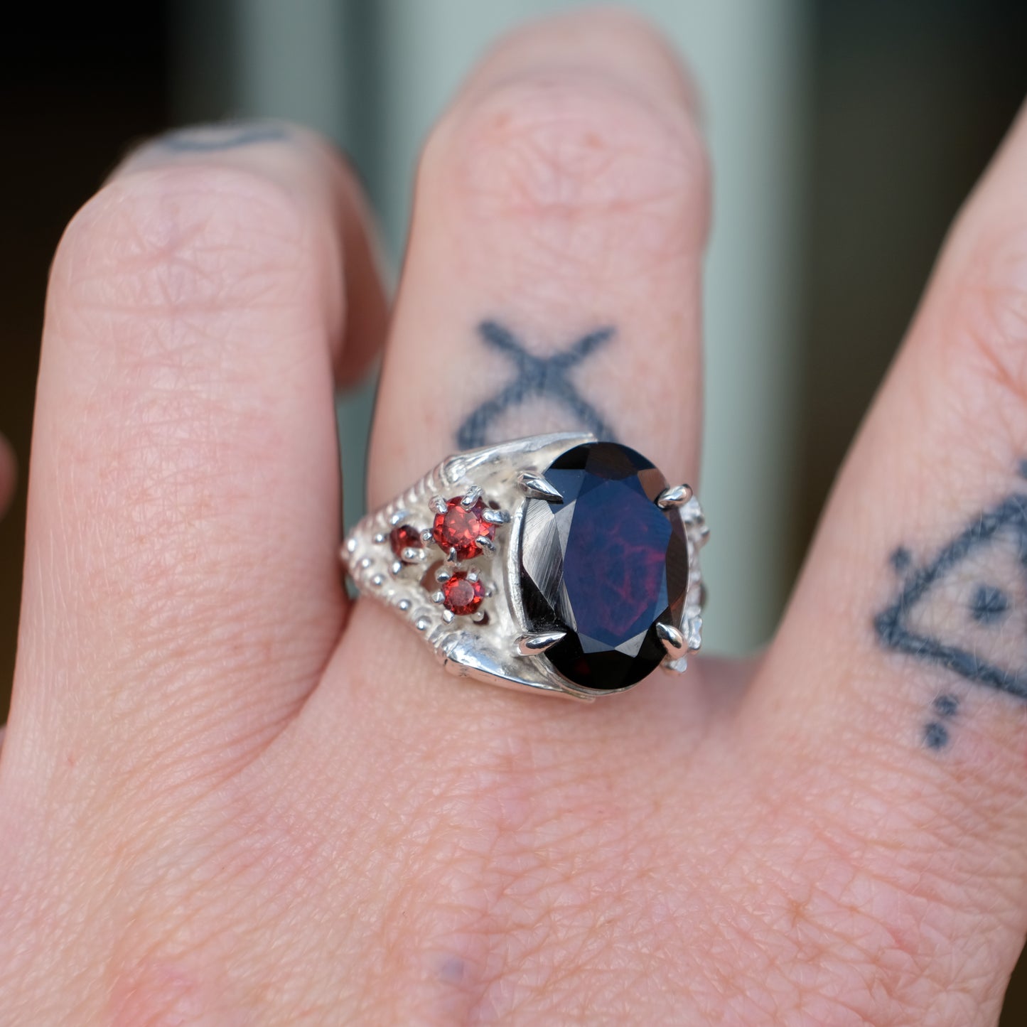 Silver birds talon claw ring with garnet stones by Charlie Shires
