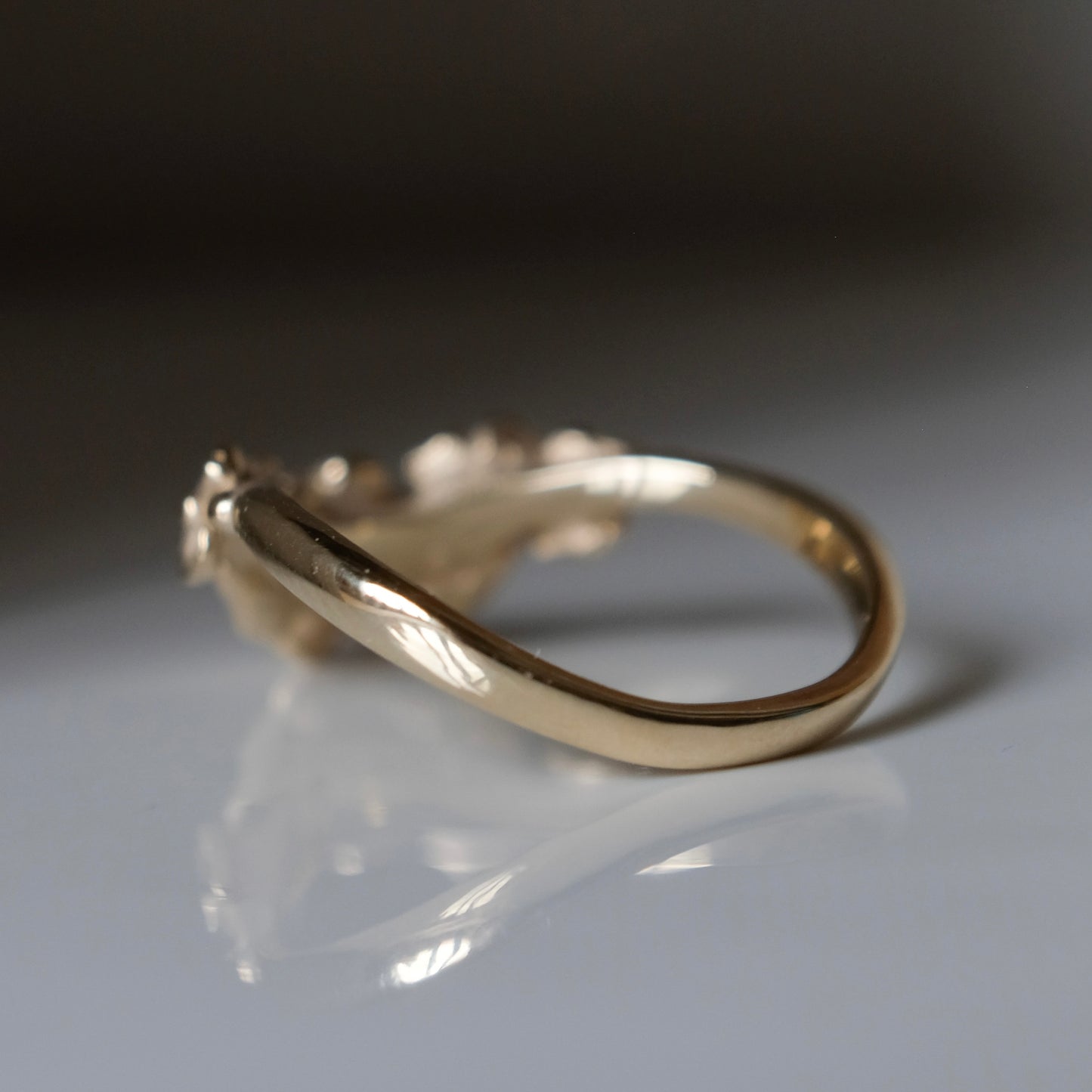 Wishbone shaped stack ring decorated with flowers and leaves. Made in London in 9ct yellow gold by Charlie Shires