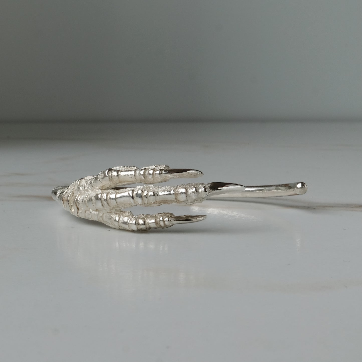 Sterling silver birds claw talon bangle handmade in London by Charlie Shires