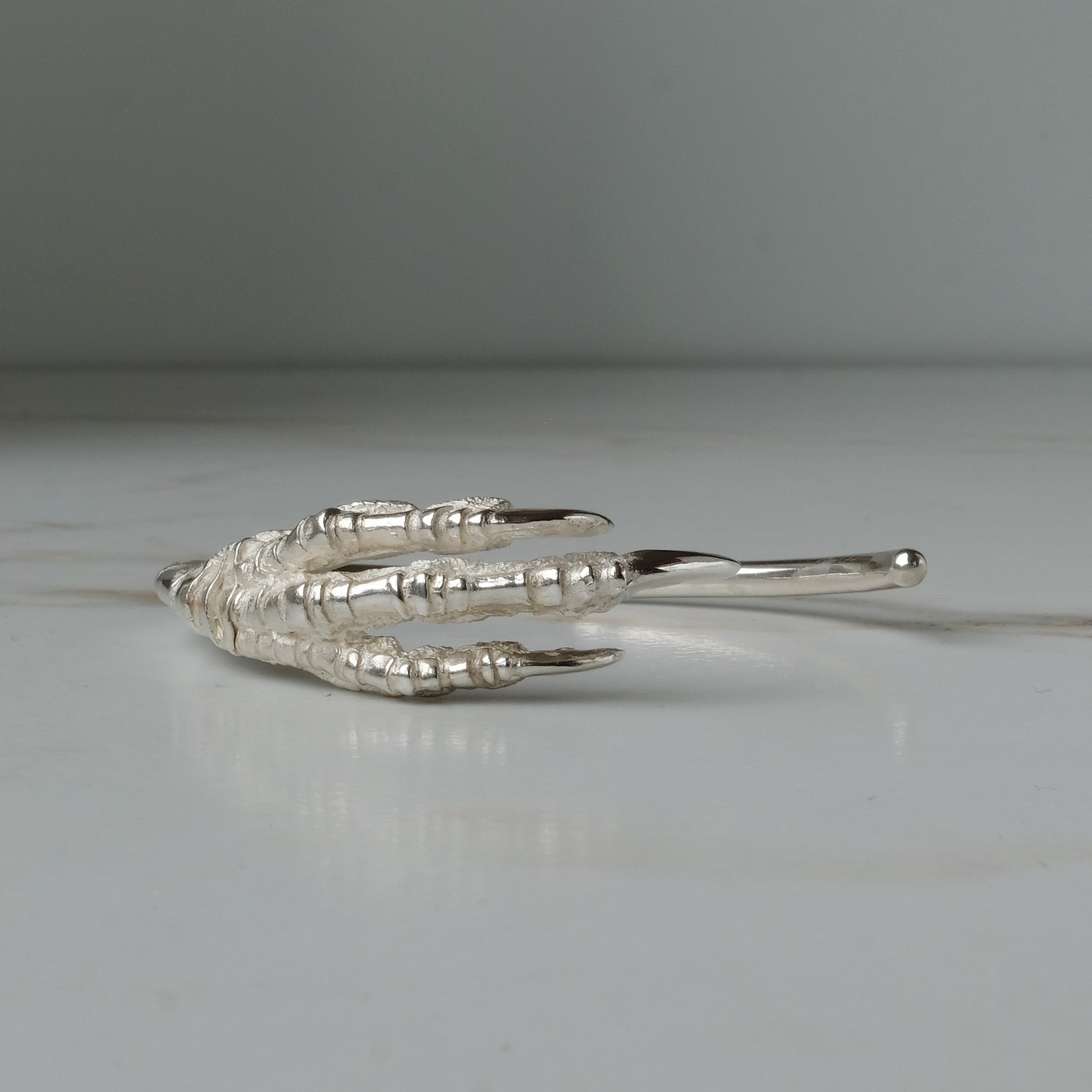 Sterling silver birds claw talon bangle handmade in London by Charlie Shires