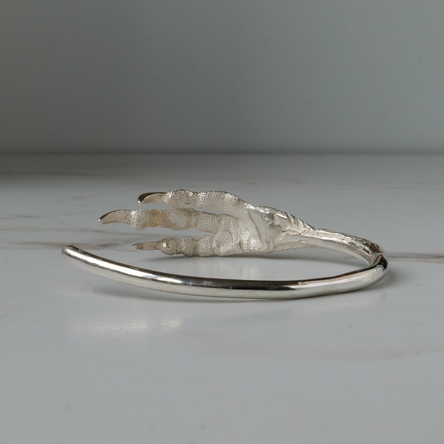 Sterling silver birds claw talon bangle handmade in London by Charlie Shires