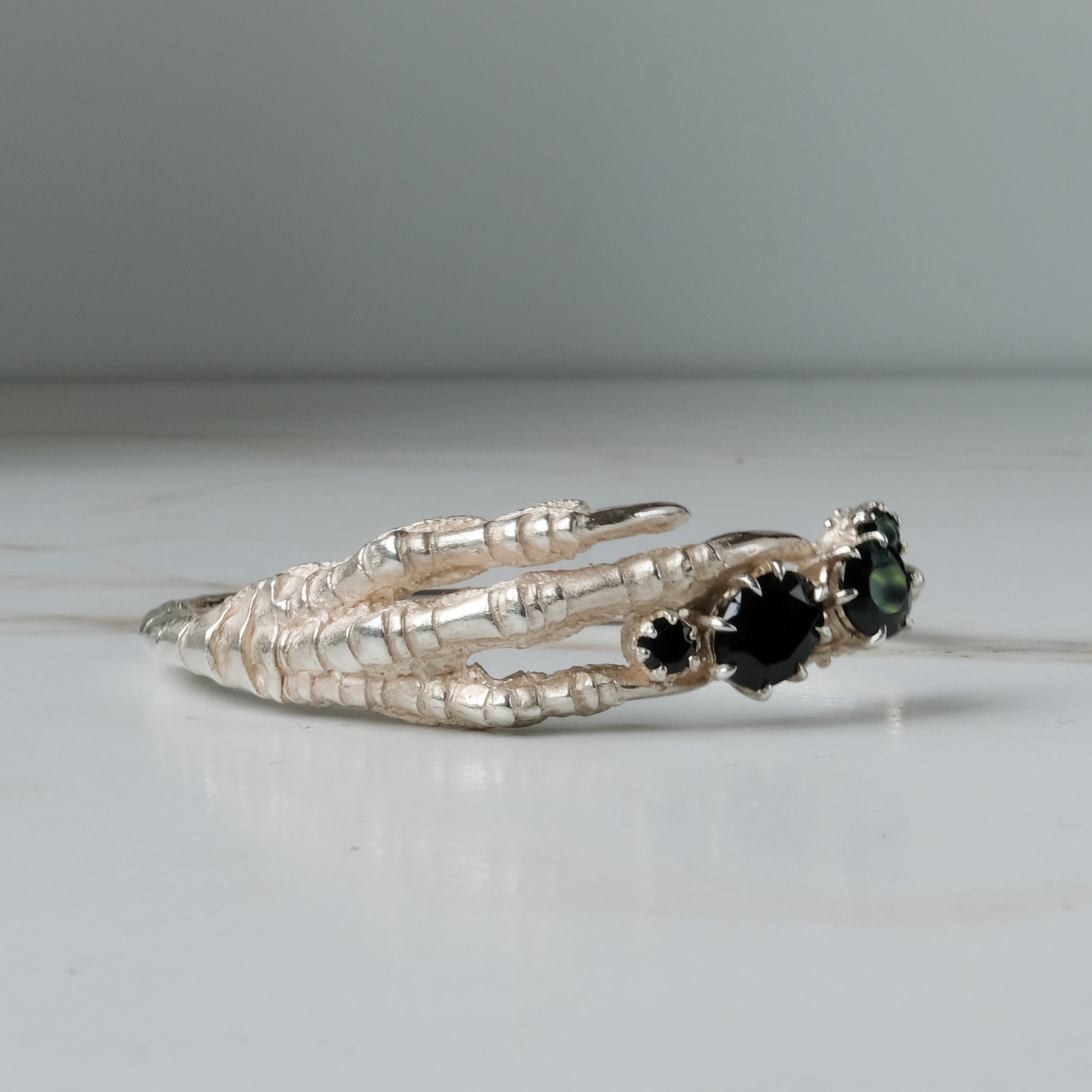 Sterling silver birds claw talon bangle handmade with black spinel stones and flowers in London by Charlie Shires