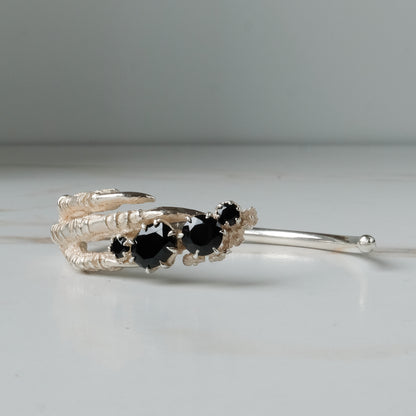 Sterling silver birds claw talon bangle handmade with black spinel stones and flowers in London by Charlie Shires