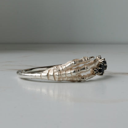 Sterling silver birds claw talon bangle handmade with black spinel stones and flowers in London by Charlie Shires