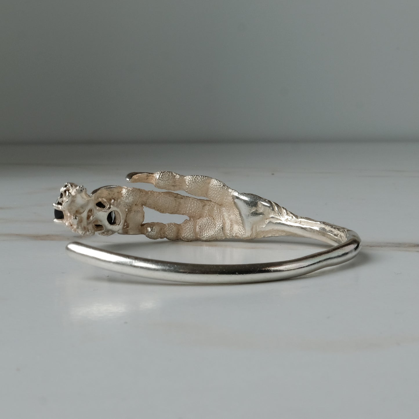 Sterling silver birds claw talon bangle handmade with black spinel stones and flowers in London by Charlie Shires