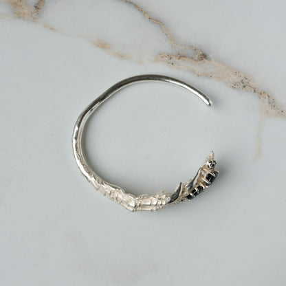 Sterling silver birds claw talon bangle handmade with black spinel stones and flowers in London by Charlie Shires