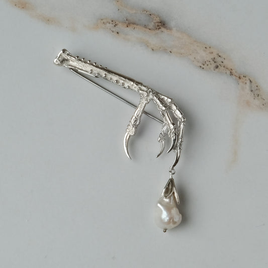 Birds claw talon brooch made in sterling silver with drop freshwater pearl. Made in London by Charlie Shires