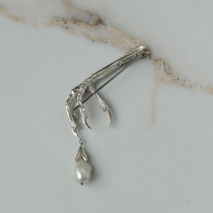 Birds claw talon brooch made in sterling silver with drop freshwater pearl. Made in London by Charlie Shires
