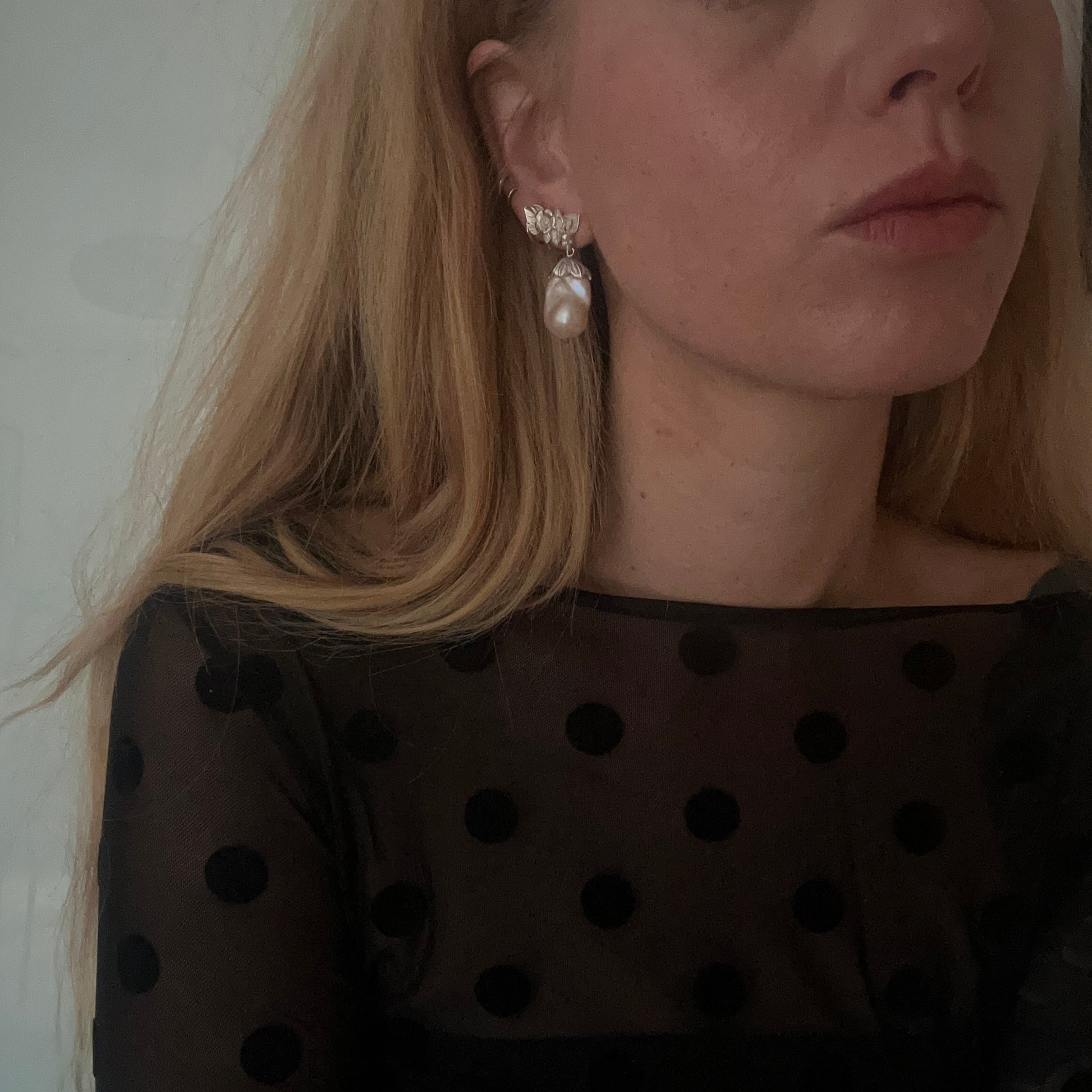 Silver stud earrings with skulls, flowers and baroque pearls. Made in recycled silver in London by Charlie Shires