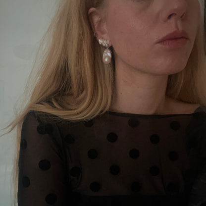 Silver stud earrings with skulls, flowers and baroque pearls. Made in recycled silver in London by Charlie Shires