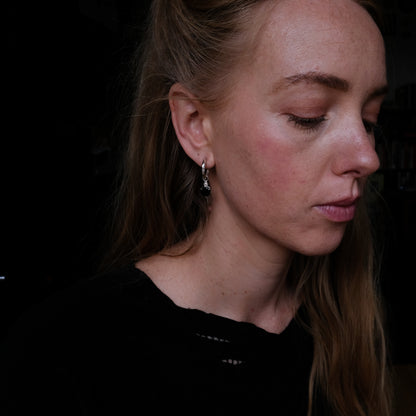 Sterling silver Annie molten hoops with drop black spinel hearts and skulls. Made in London by Charlie Shires