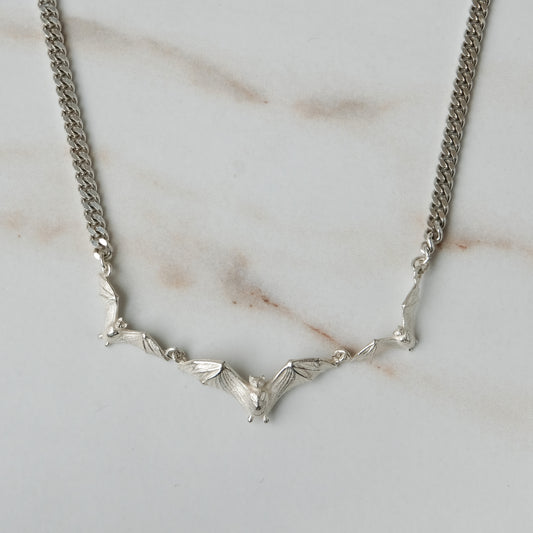 Three bat necklace on curb link chain, made in sterling silver by Charlie Shires in London