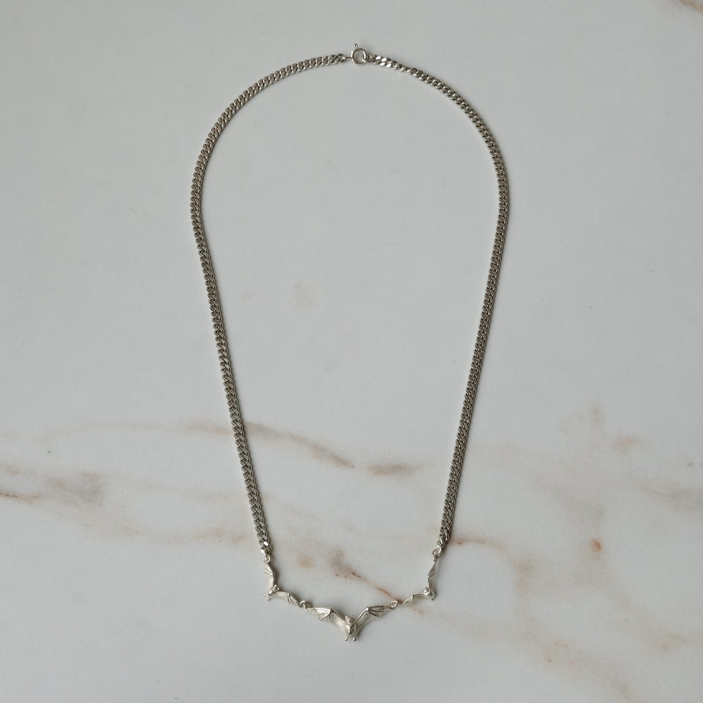 Three bat necklace on curb link chain, made in sterling silver by Charlie Shires in London