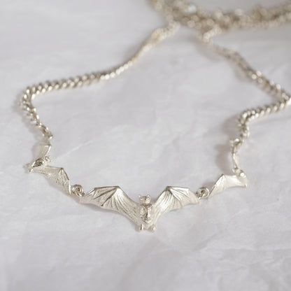 Three bat necklace on curb link chain, made in sterling silver by Charlie Shires in London