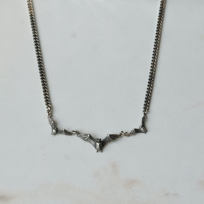 Three bat necklace on curb link chain, made in sterling silver by Charlie Shires in London
