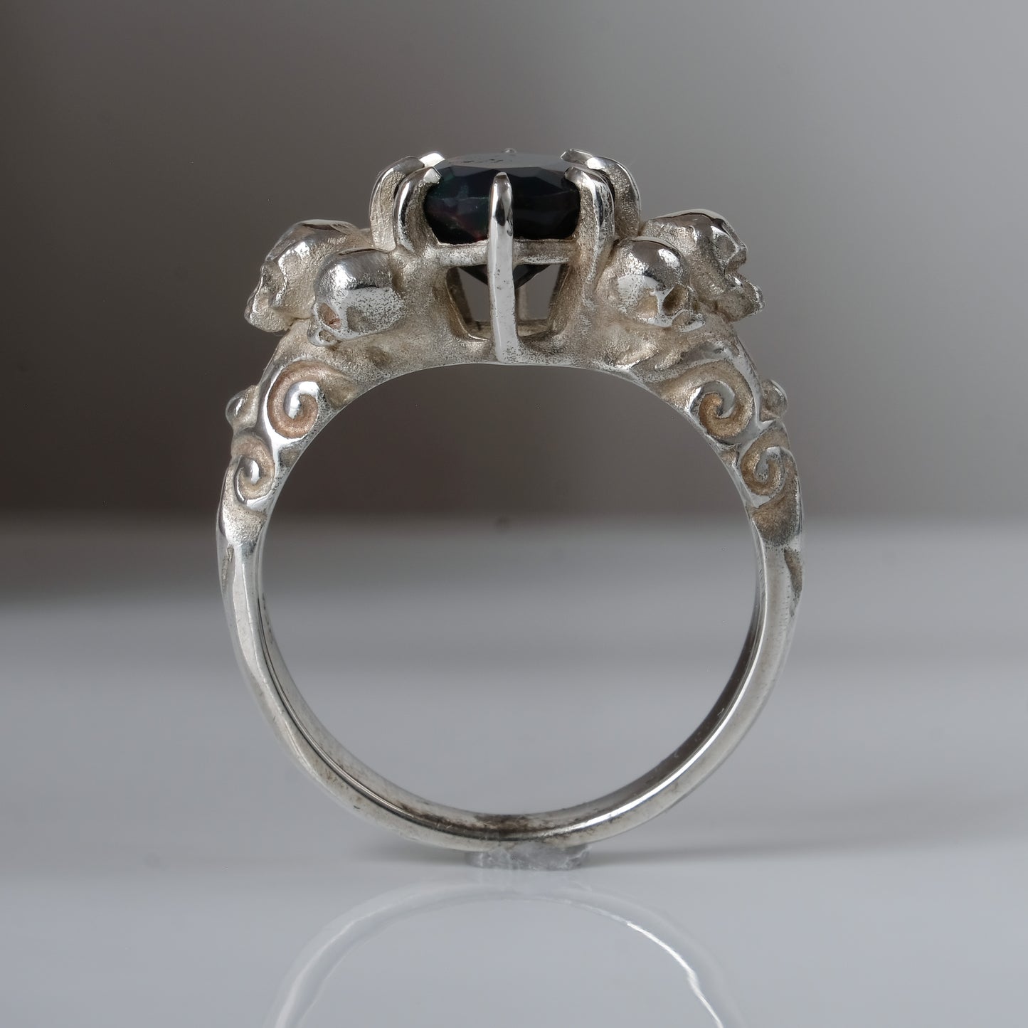 Three skull ring with central black opal and decorative band by Charlie Shires