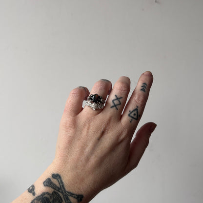 Three skull ring with central black opal and decorative band by Charlie Shires