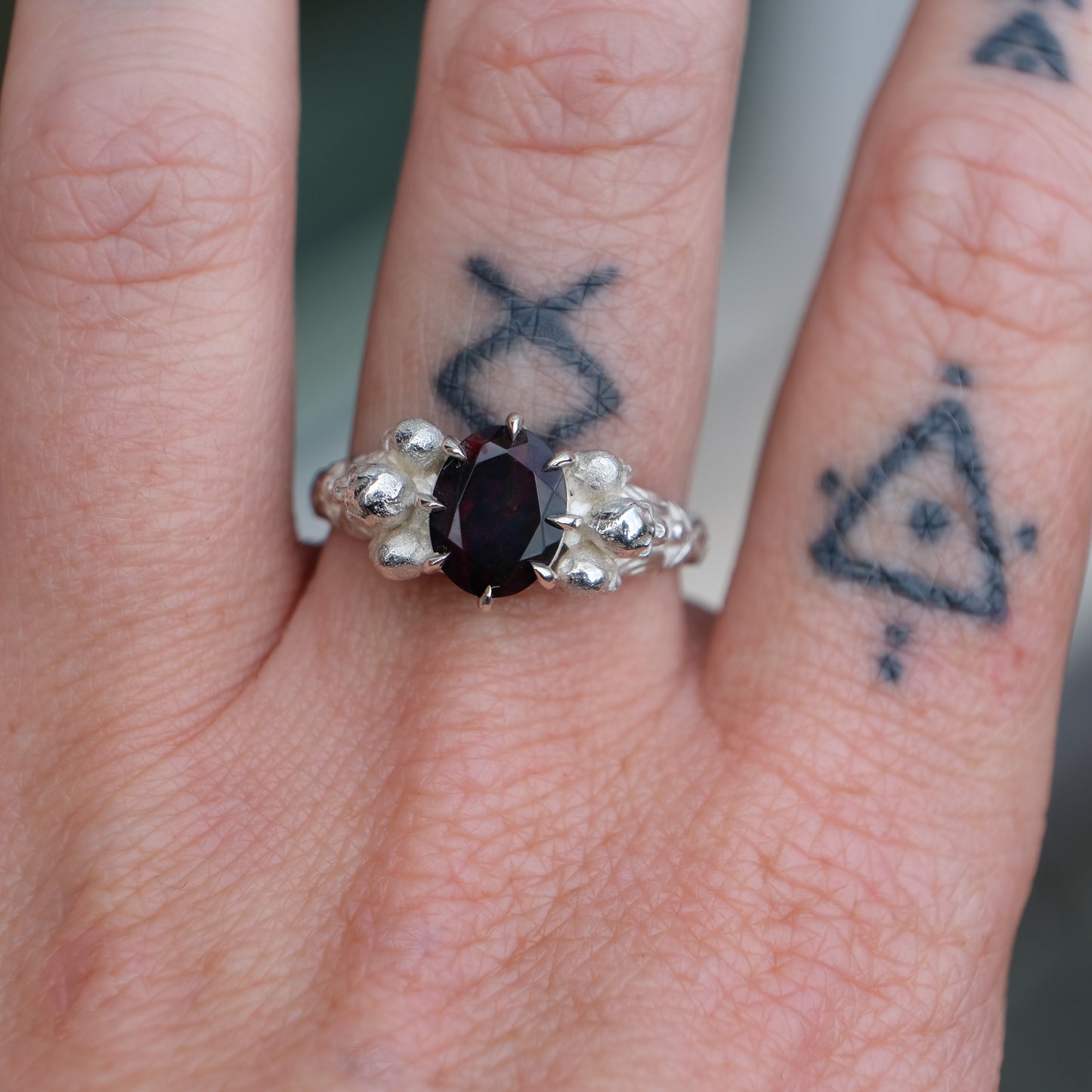 Three skull ring with central black opal and decorative band by Charlie Shires