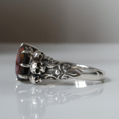Three skull ring with central black opal and decorative band by Charlie Shires