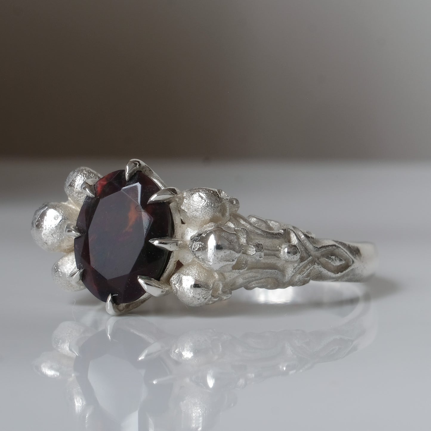 Three skull ring with central black opal and decorative band by Charlie Shires