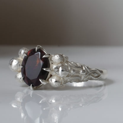 Three skull ring with central black opal and decorative band by Charlie Shires