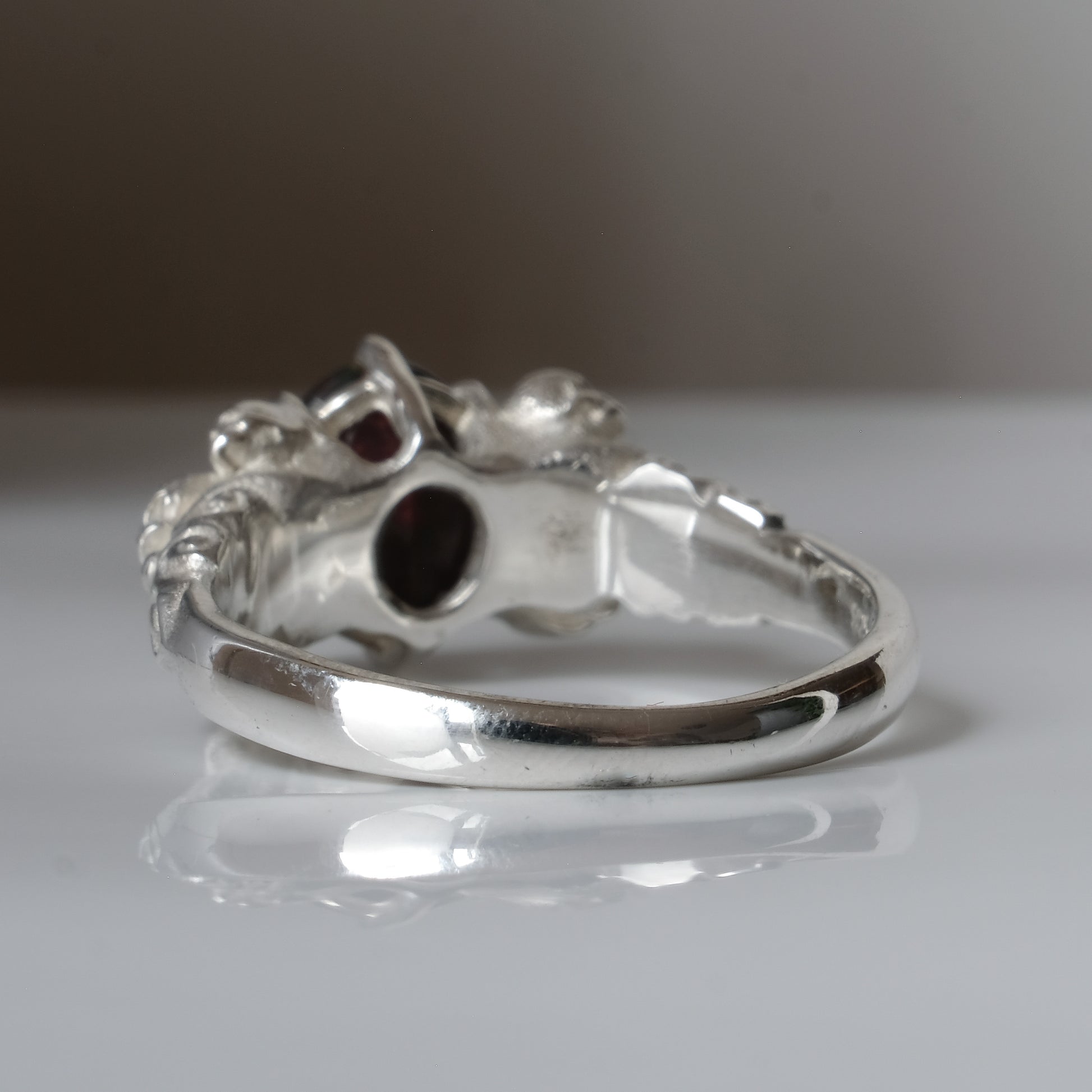 Three skull ring with central black opal and decorative band by Charlie Shires