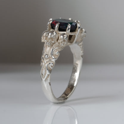 Three skull ring with central black opal and decorative band by Charlie Shires