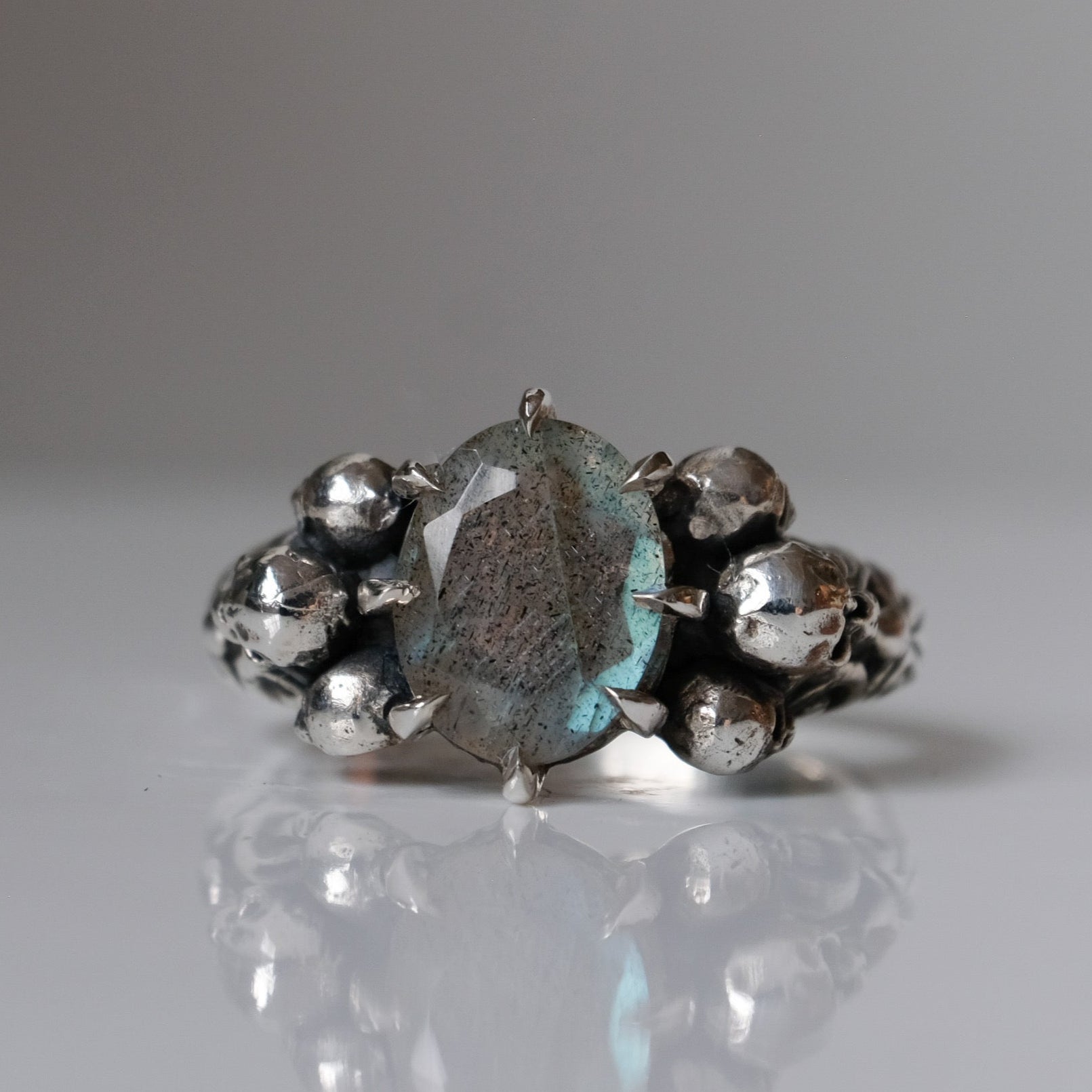 Three skull ring with central labradorite and decorative band made in sterling silver in London by Charlie Shires