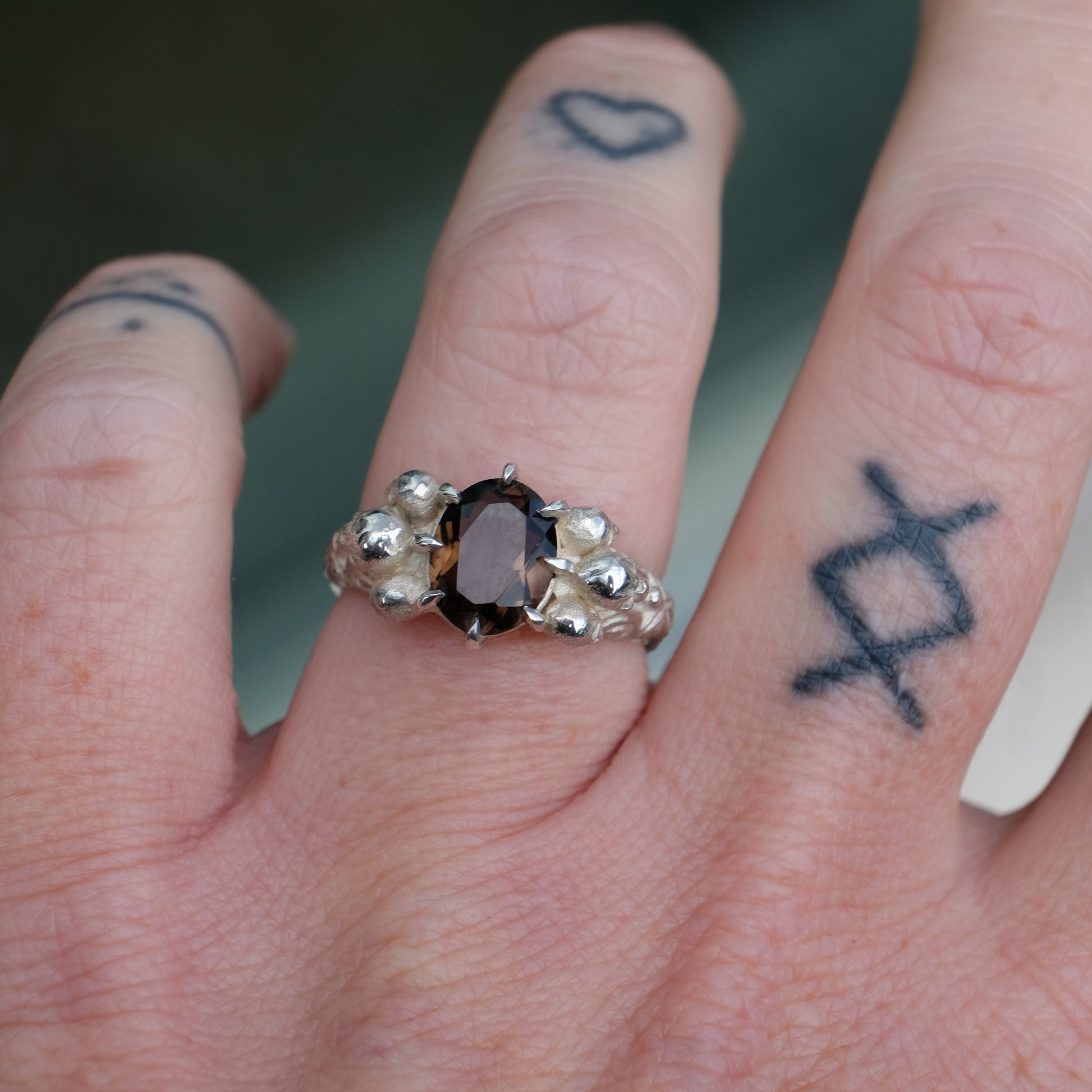 Three skull ring with central tourmaline and decorative band made in sterling silver in London by Charlie Shires