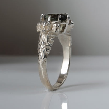 Three skull ring with central tourmaline and decorative band
