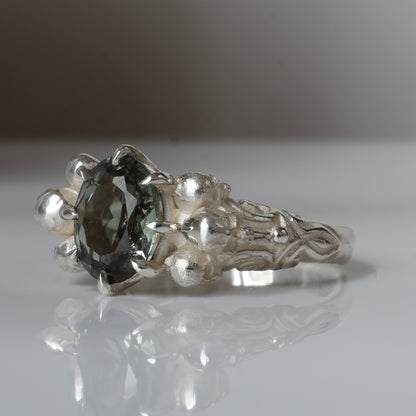 Three skull ring with central tourmaline and decorative band