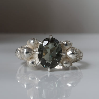 Three skull ring with central tourmaline and decorative band