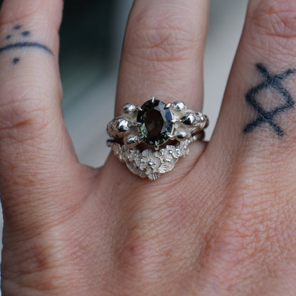 Three skull ring with central tourmaline and decorative band