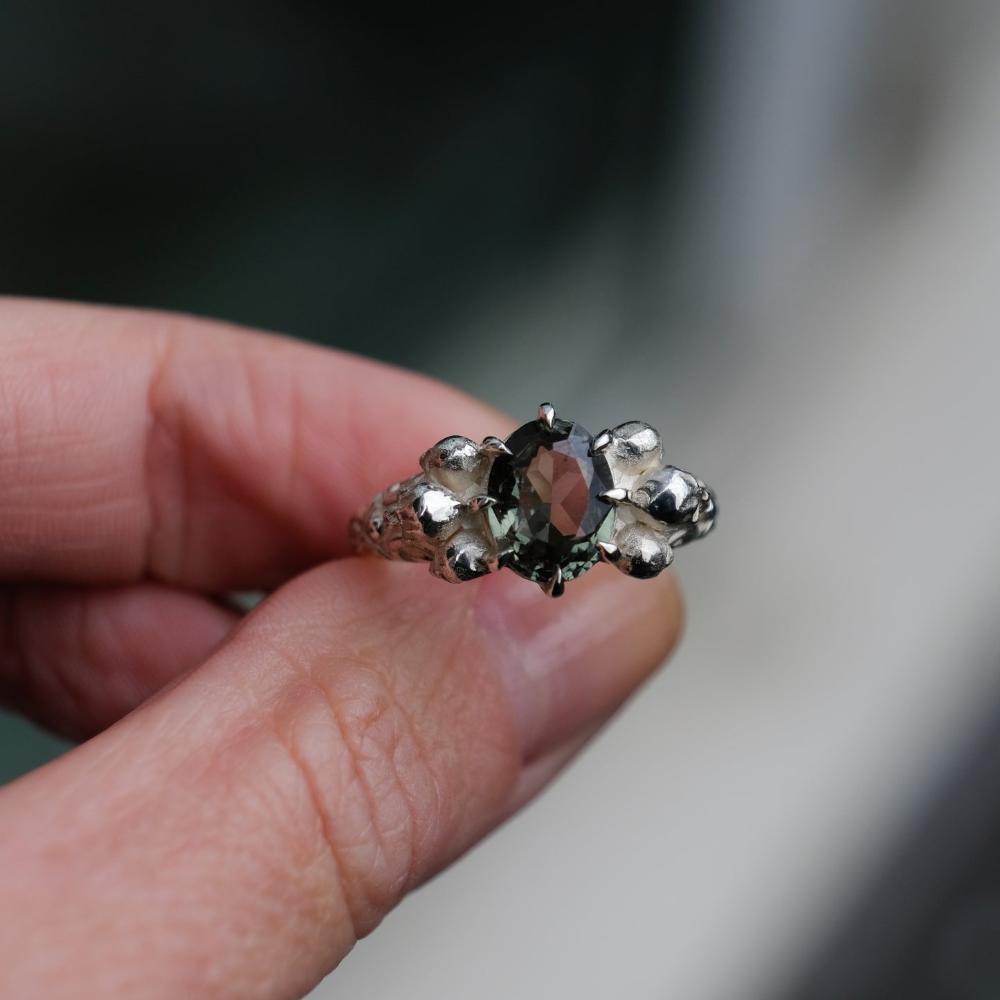 Three skull ring with central tourmaline and decorative band