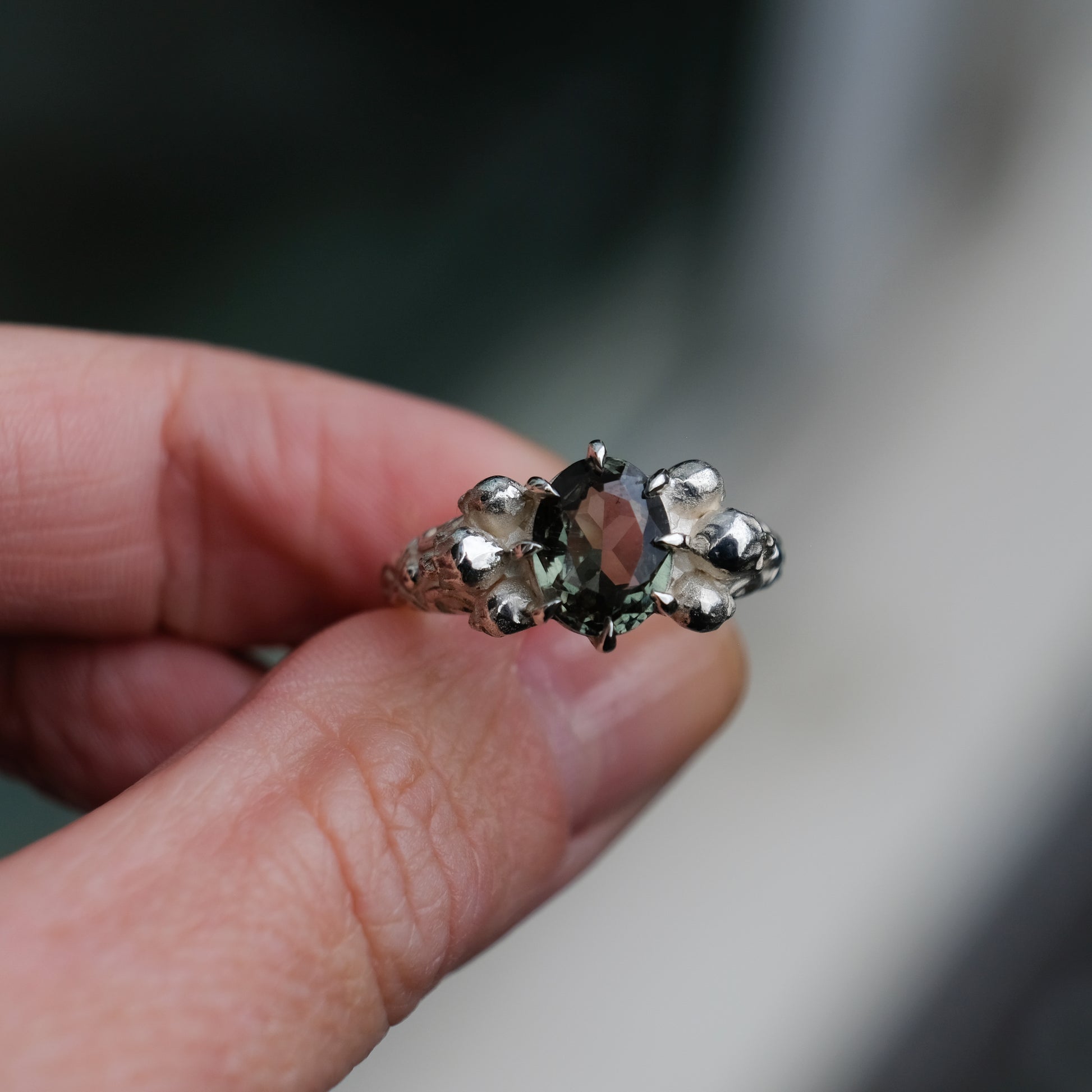 Three skull ring with central tourmaline and decorative band