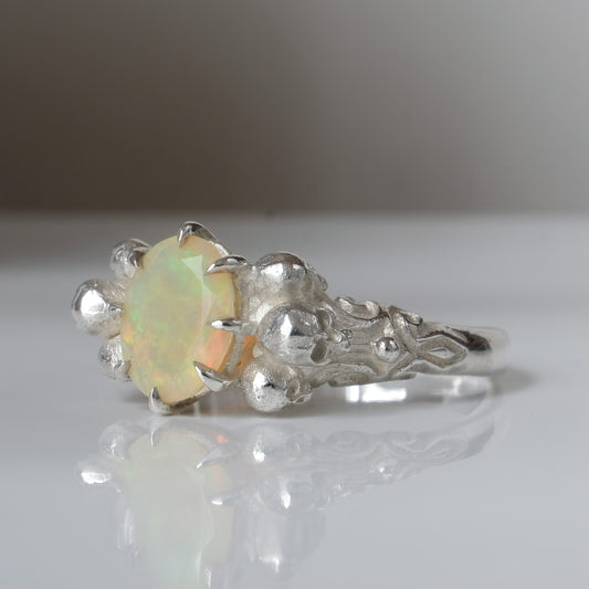 Three skull ring with central white opal and decorative band by Charlie Shires
