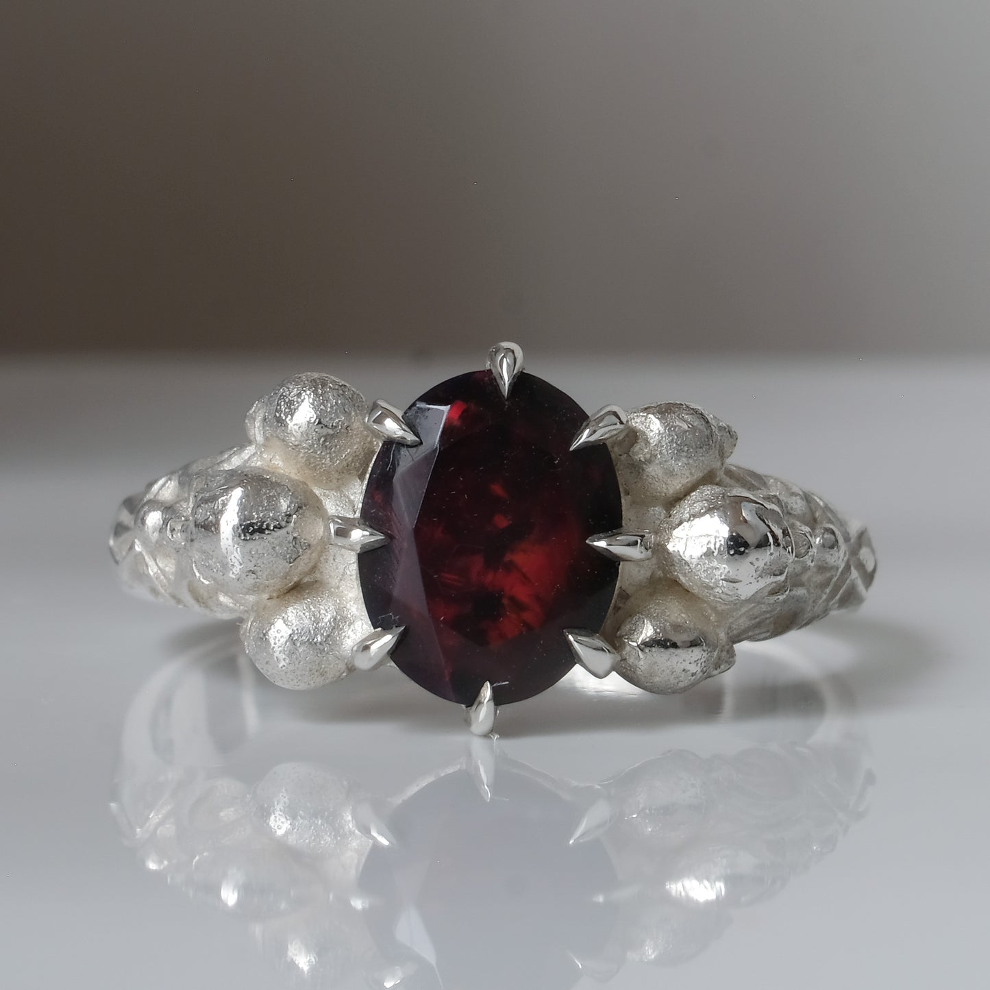 Three skull ring with central black opal and decorative band by Charlie Shires