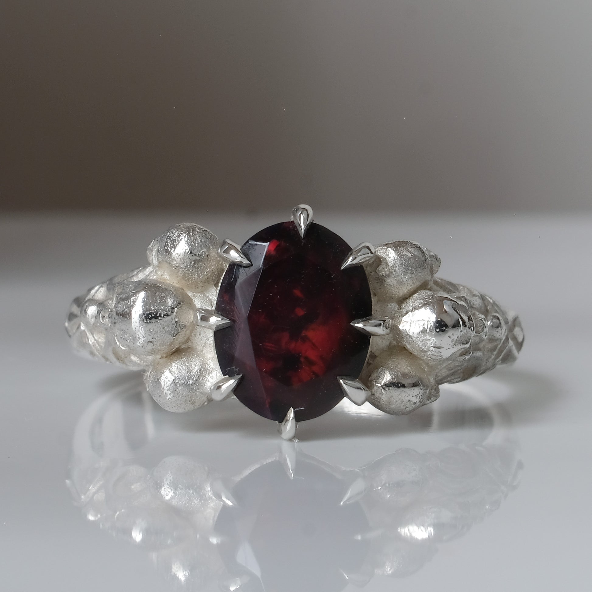 Three skull ring with central black opal and decorative band by Charlie Shires