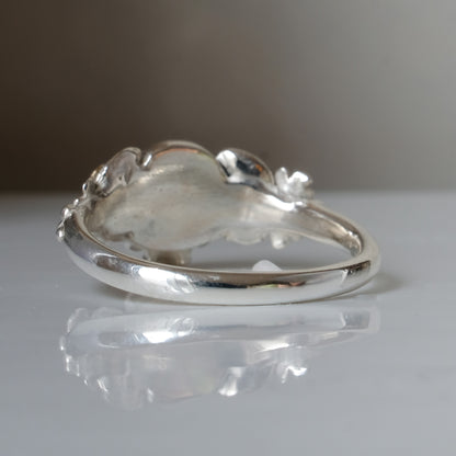 Sterling silver ring with central skull and 9ct yellow gold flower and leaves cascading down band. Handmade in London by Charlie Shires