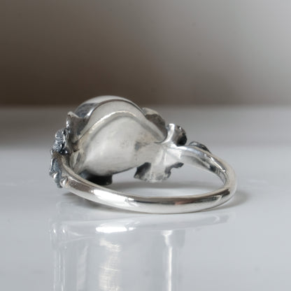 Sterling silver ring with central large skull and flower and leaves cascading down band. Handmade in London by Charlie Shires
